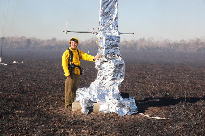 A student in the field with a yellow jacket